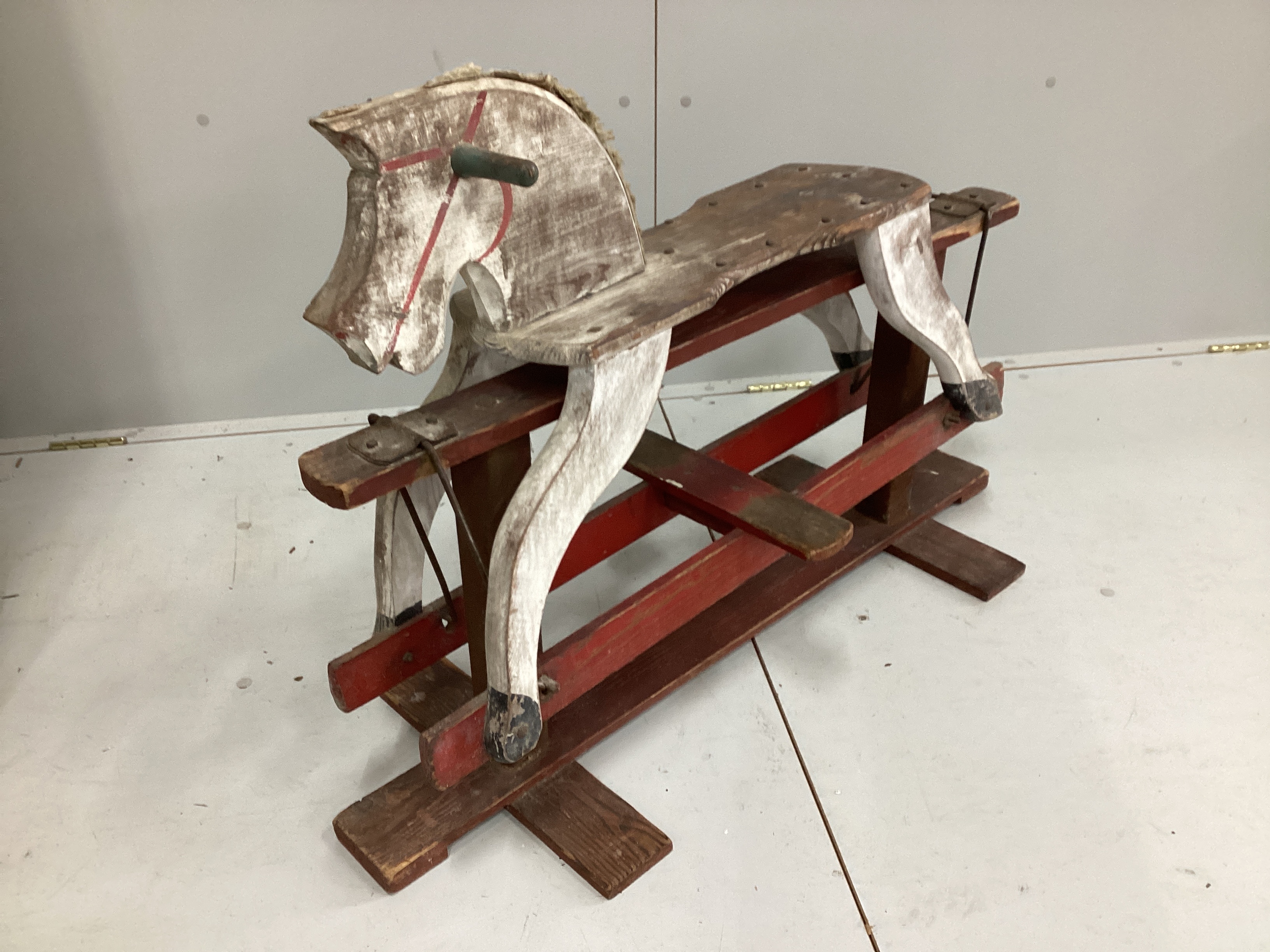 A primitive painted pine rocking horse, length 99cm